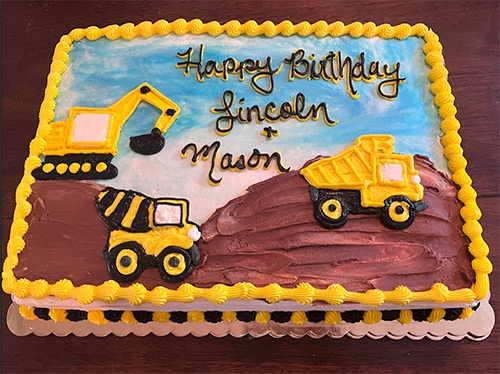 A diggerland themed sheet cake that says Happy Birthday Lincoln and Mason