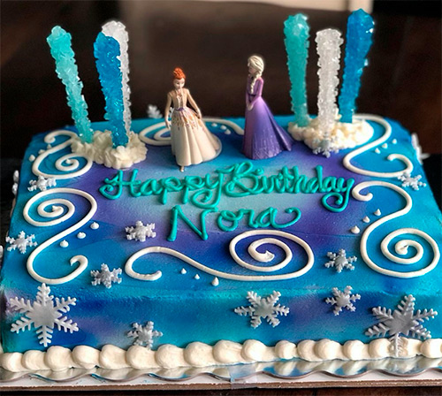 A Disney's Frozen inspired sheet cake that with Elsa and Ana figures on top