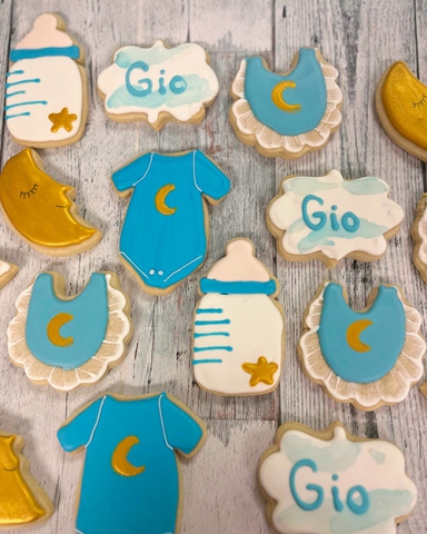 Blue and gold baby themed decorated sugar cookies for Gio that include baby bibs and bottles