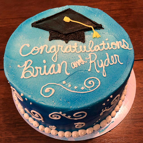 A graduation cake with writing that says Congratulations Brian and Rider