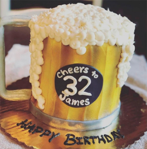 a cake shaped like a Beer Glass with overflowing beer foam that says cheer to 32 James Happy Birthday