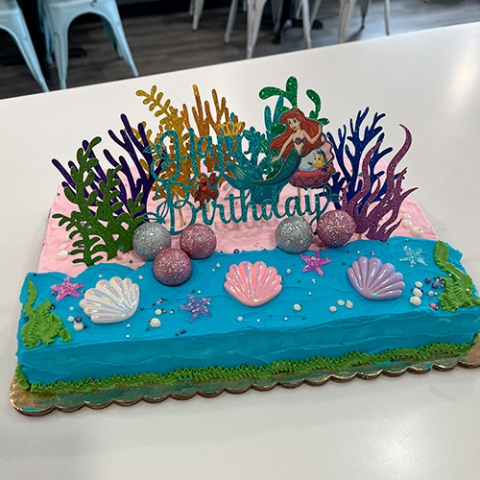 The Little Mermaid themed sheet cake with Ariel, coral, and seashell on top