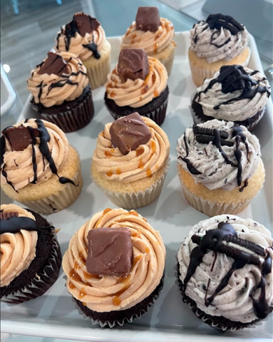 a display of oreo, snickers and reeses peanut butter cupcakes