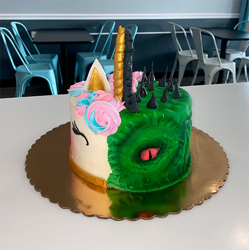 a round cake that is half unicorn and half dragon